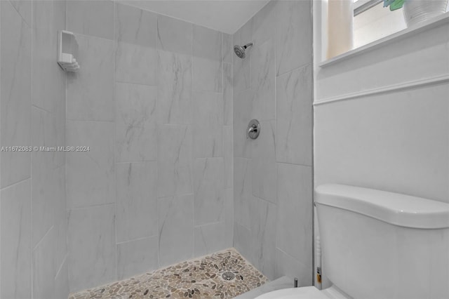 bathroom featuring toilet and tiled shower