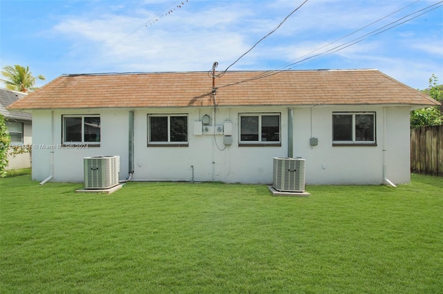 back of house featuring a yard and central AC unit