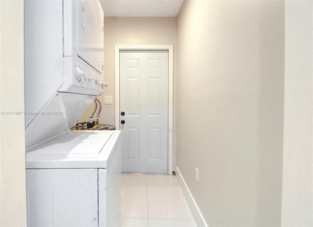 washroom with stacked washer / dryer and light tile patterned flooring