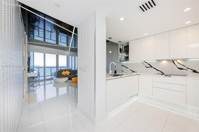 17121 Collins Ave Unit 1103, Sunny Isles Beach, FL 33160 - kitchen with expansive windows, modern cabinets, white cabinetry, light tile patterned floors, and light countertops