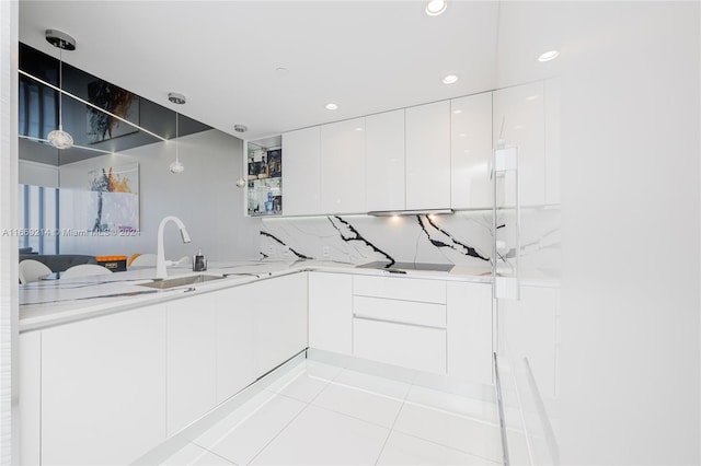 kitchen with pendant lighting, white cabinetry, kitchen peninsula, decorative backsplash, and light tile patterned floors