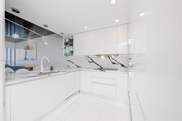 17121 Collins Ave Unit 1103, Sunny Isles Beach, FL 33160 - kitchen with modern cabinets, white cabinetry, tasteful backsplash, light tile patterned floors, and a sink