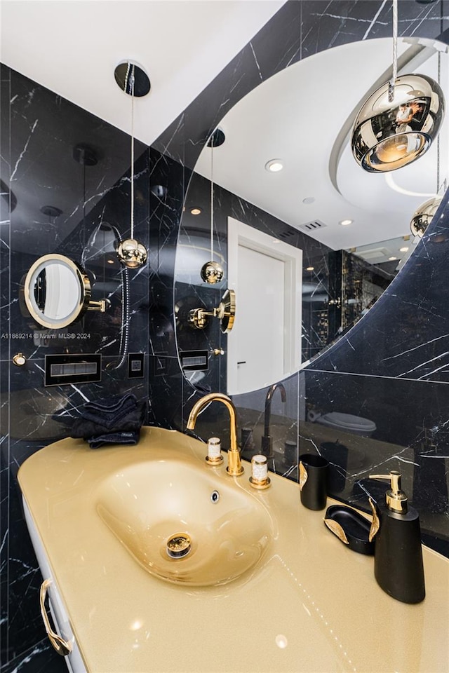 bathroom featuring tile walls, backsplash, and vanity