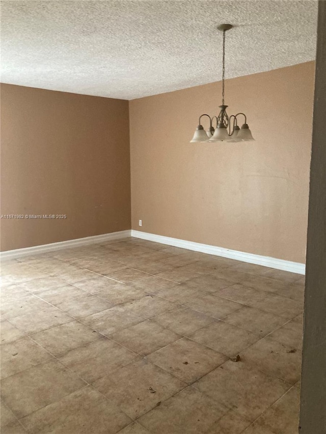 spare room with a chandelier and a textured ceiling