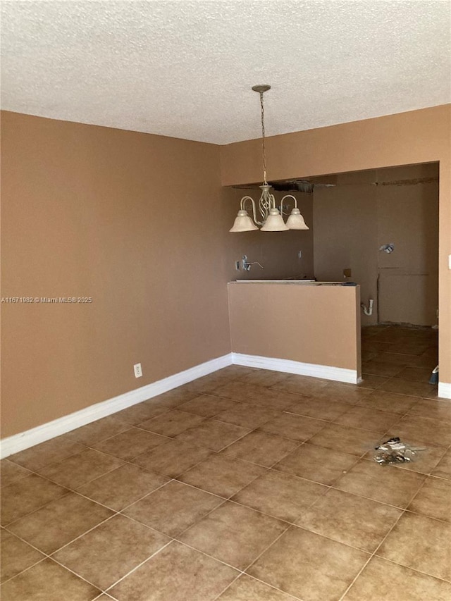 unfurnished dining area with tile patterned flooring, a textured ceiling, and an inviting chandelier