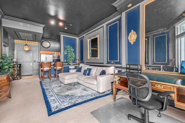 carpeted home theater room with ornamental molding and a textured ceiling