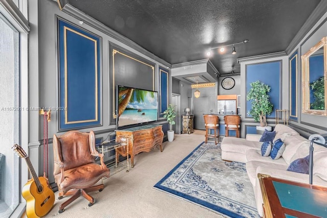 home theater room featuring a textured ceiling, crown molding, carpet, and rail lighting