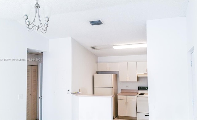 kitchen featuring a textured ceiling and white appliances