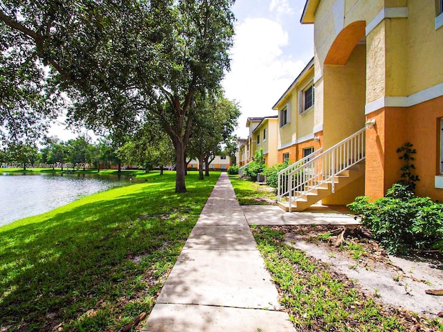 view of property's community with a yard and a water view