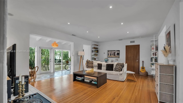 living room with beamed ceiling and hardwood / wood-style flooring