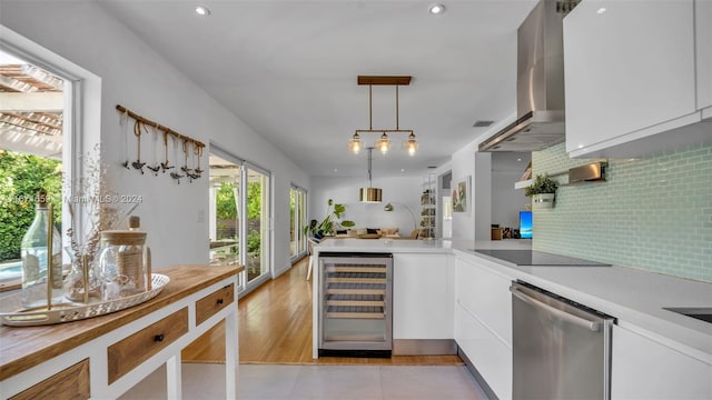 kitchen featuring beverage cooler, white cabinetry, and hanging light fixtures