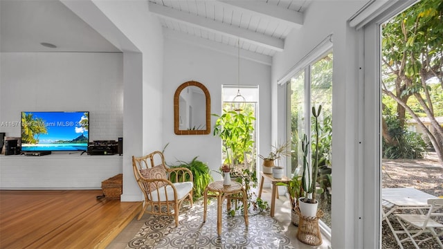 sunroom featuring lofted ceiling with beams