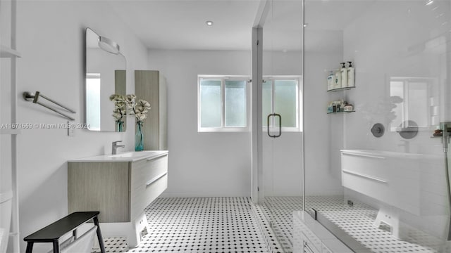 bathroom featuring a shower with shower door and vanity