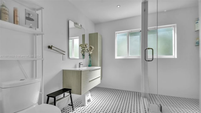 bathroom featuring vanity, a shower with shower door, and toilet