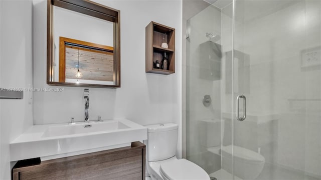 bathroom with a shower with shower door, vanity, and toilet