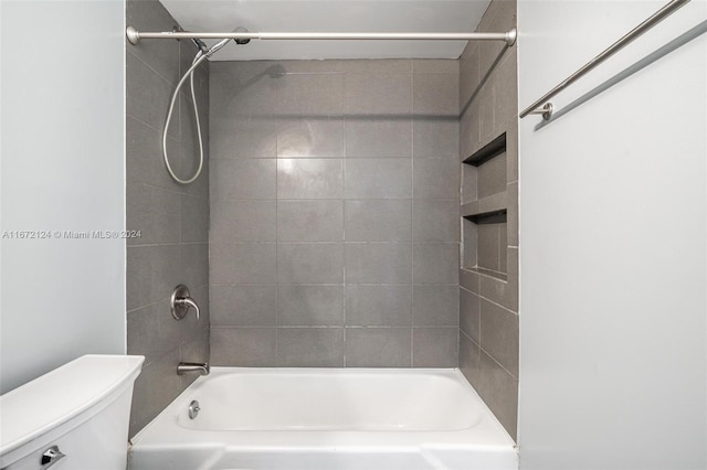 bathroom featuring tiled shower / bath and toilet