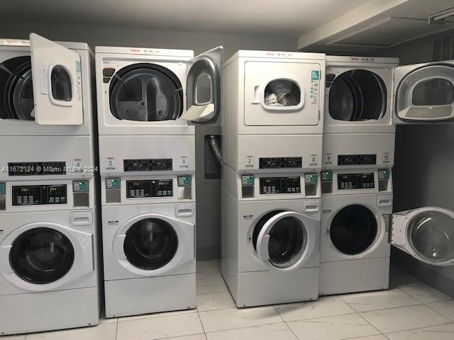 clothes washing area featuring washer and clothes dryer and stacked washing maching and dryer