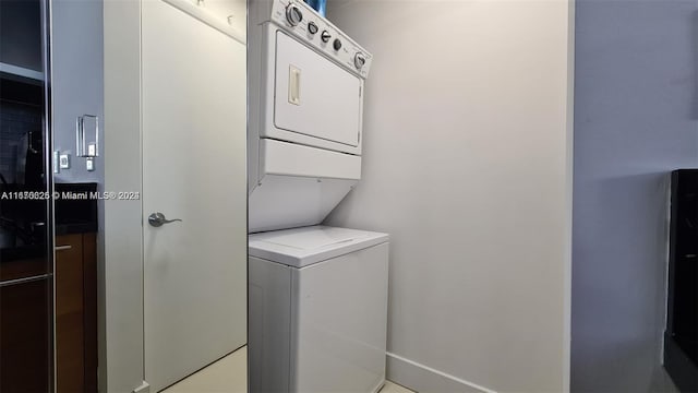 clothes washing area featuring stacked washing maching and dryer