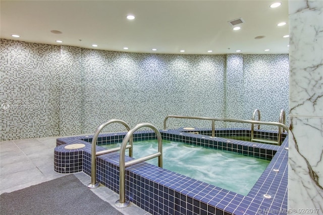 view of swimming pool with an indoor hot tub