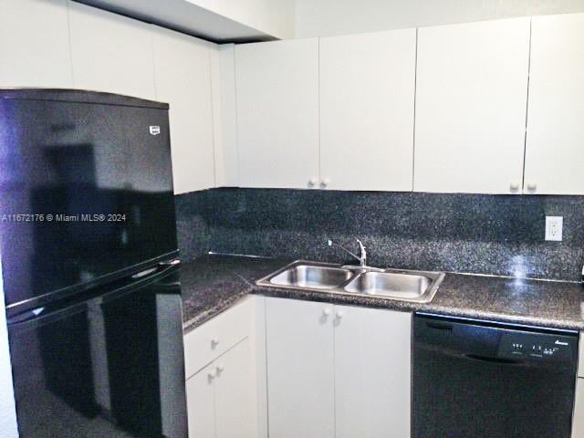 kitchen featuring backsplash, sink, white cabinets, and black appliances