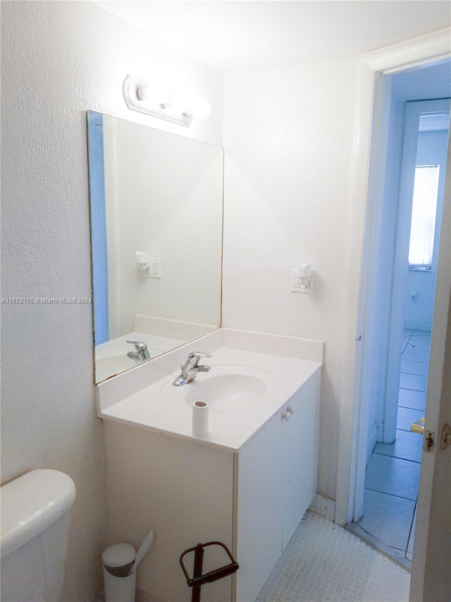 bathroom featuring tile patterned floors, vanity, and toilet