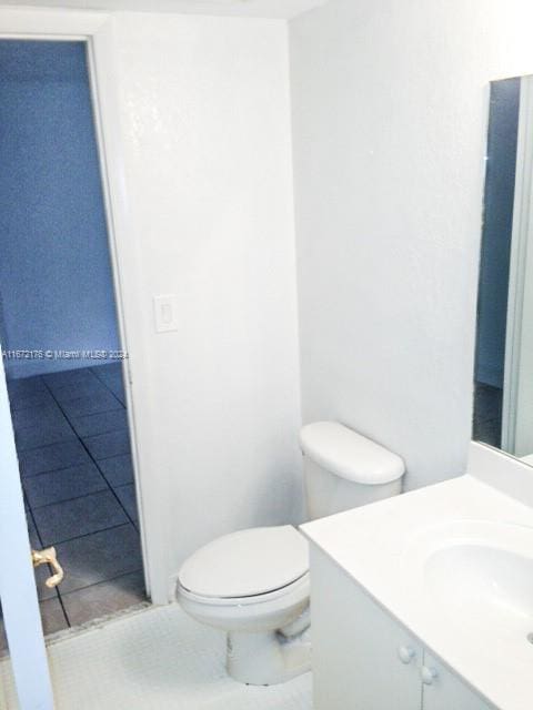 bathroom with tile patterned flooring, vanity, and toilet