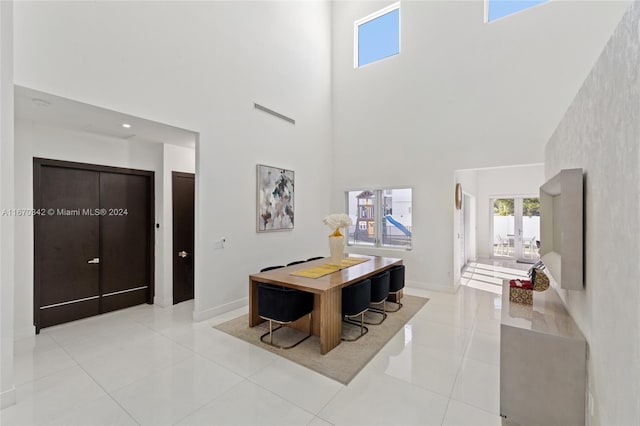 tiled dining area featuring french doors and a high ceiling