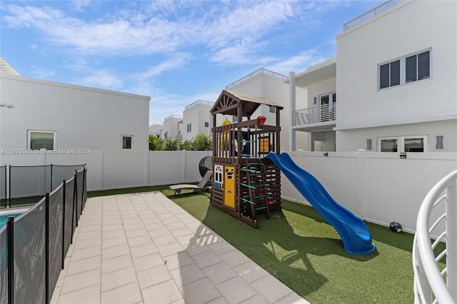 view of jungle gym featuring a lawn and a patio