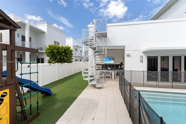 view of patio / terrace with a balcony and a fenced in pool