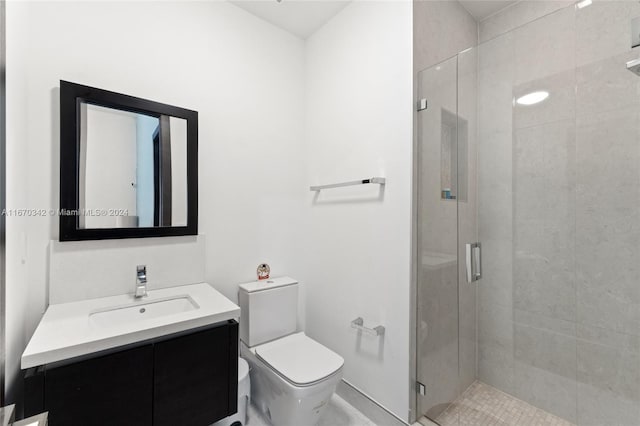 bathroom with vanity, toilet, and a shower with shower door