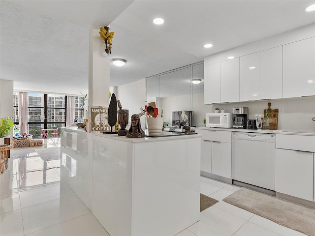 kitchen featuring white cabinetry, white appliances, expansive windows, and light tile patterned floors