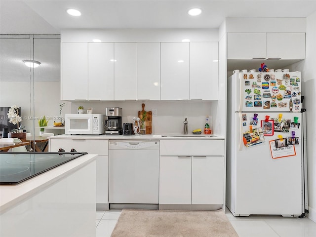 kitchen with white cabinetry, white appliances, light tile patterned flooring, and sink