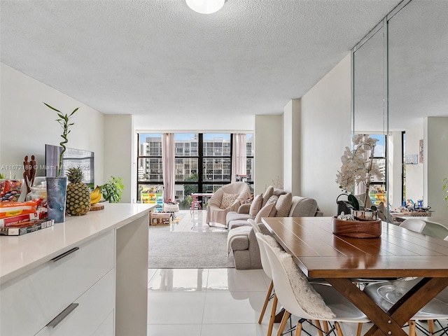 dining space featuring expansive windows, a textured ceiling, and light tile patterned floors