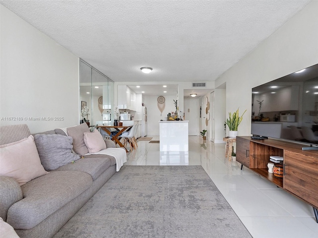 tiled living room featuring a textured ceiling