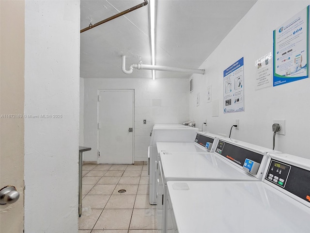 laundry room with washing machine and dryer and light tile patterned floors