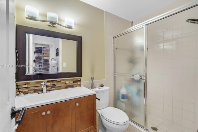 bathroom featuring walk in shower, vanity, toilet, and tasteful backsplash