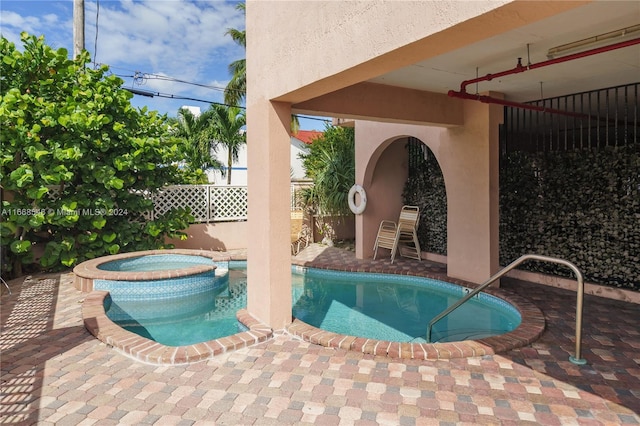 view of pool with a patio and an in ground hot tub