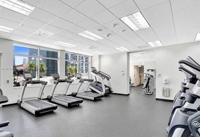 workout area with a drop ceiling and baseboards