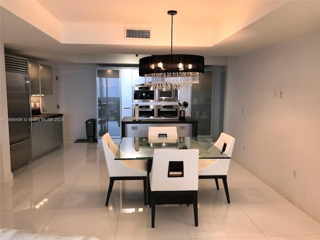 dining area with light tile patterned flooring and an inviting chandelier