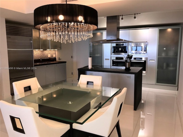 dining space featuring an inviting chandelier, light tile patterned flooring, and sink