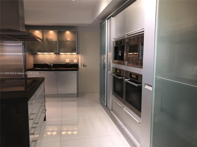 kitchen with light tile patterned flooring, sink, ventilation hood, decorative backsplash, and appliances with stainless steel finishes