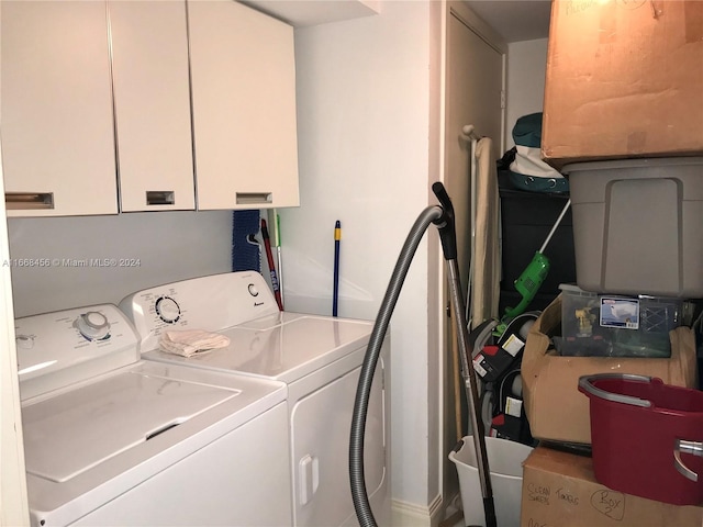 laundry area with cabinets and washing machine and clothes dryer