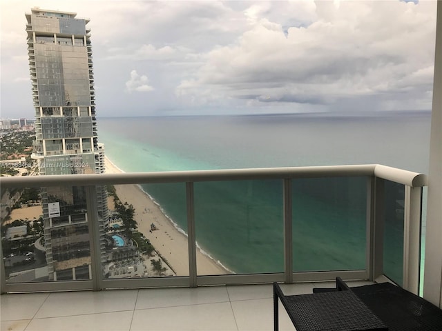 balcony featuring a water view and a beach view