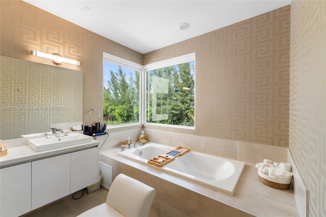 bathroom with tiled tub and vanity