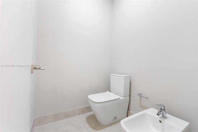 bathroom with a bidet, sink, tile patterned flooring, and toilet