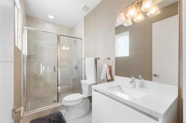 bathroom with vanity, a shower with shower door, and toilet