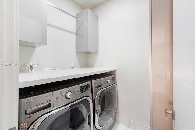 clothes washing area with cabinets and washing machine and dryer