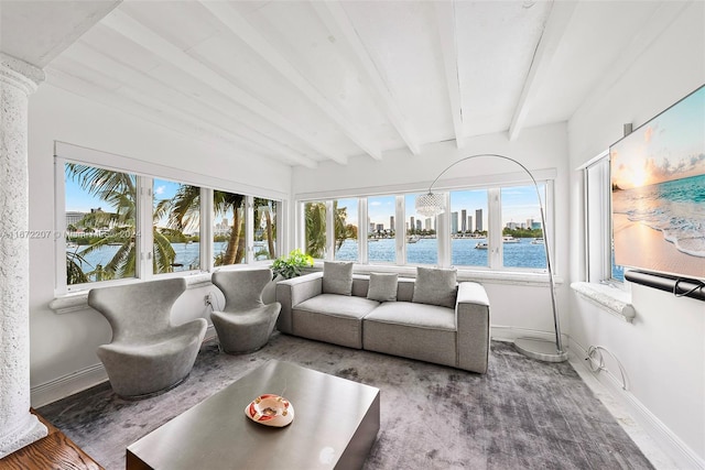 sunroom / solarium with beam ceiling and a water view