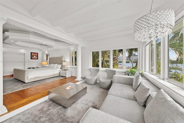 sunroom with decorative columns, a chandelier, and beam ceiling