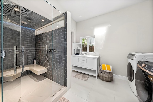 bathroom with tile patterned flooring, vanity, independent washer and dryer, and a shower with shower door